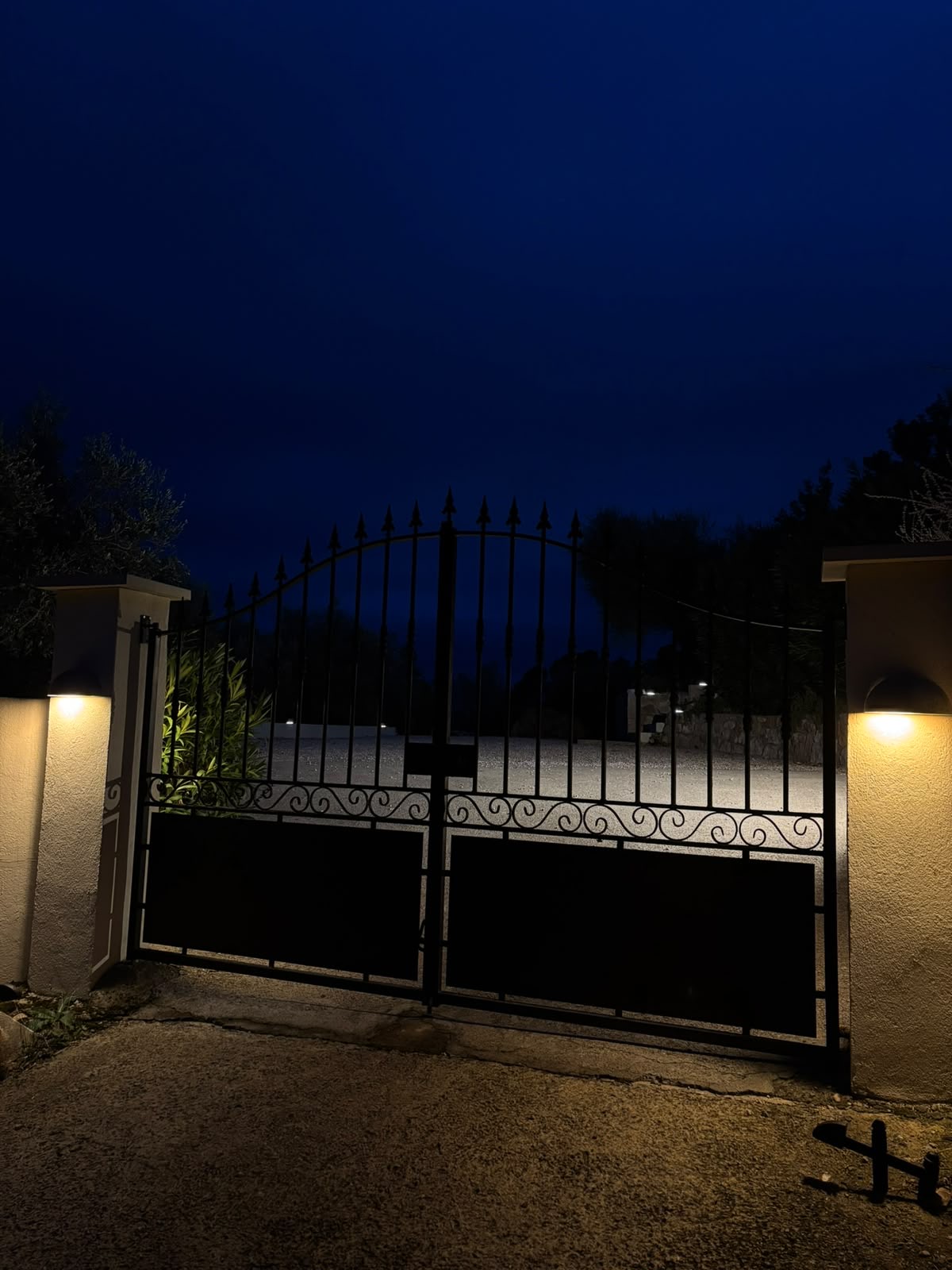 Portail en fer forgé avec éclairage appliques sur piliers de nuit, particulier Var